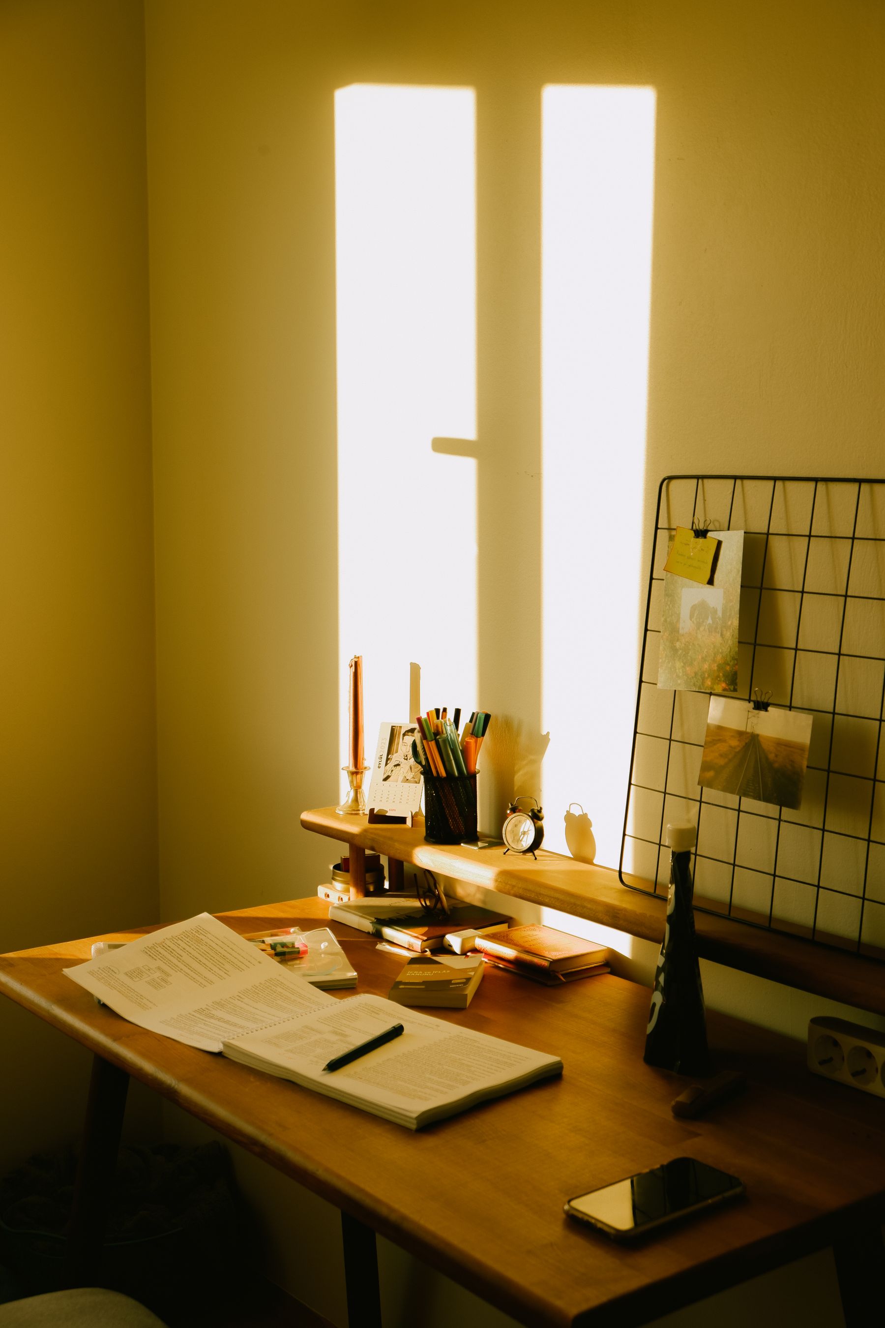 An open notebook on a desk in warm afternoon sunlight